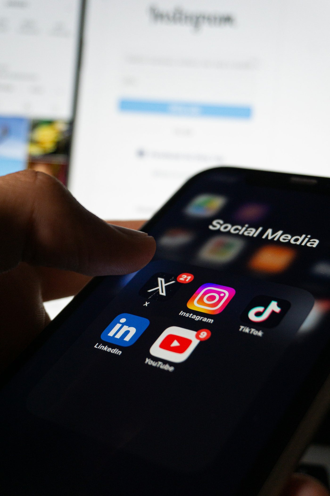 Personne tenant un smartphone affichant des réseaux sociaux à l'écran